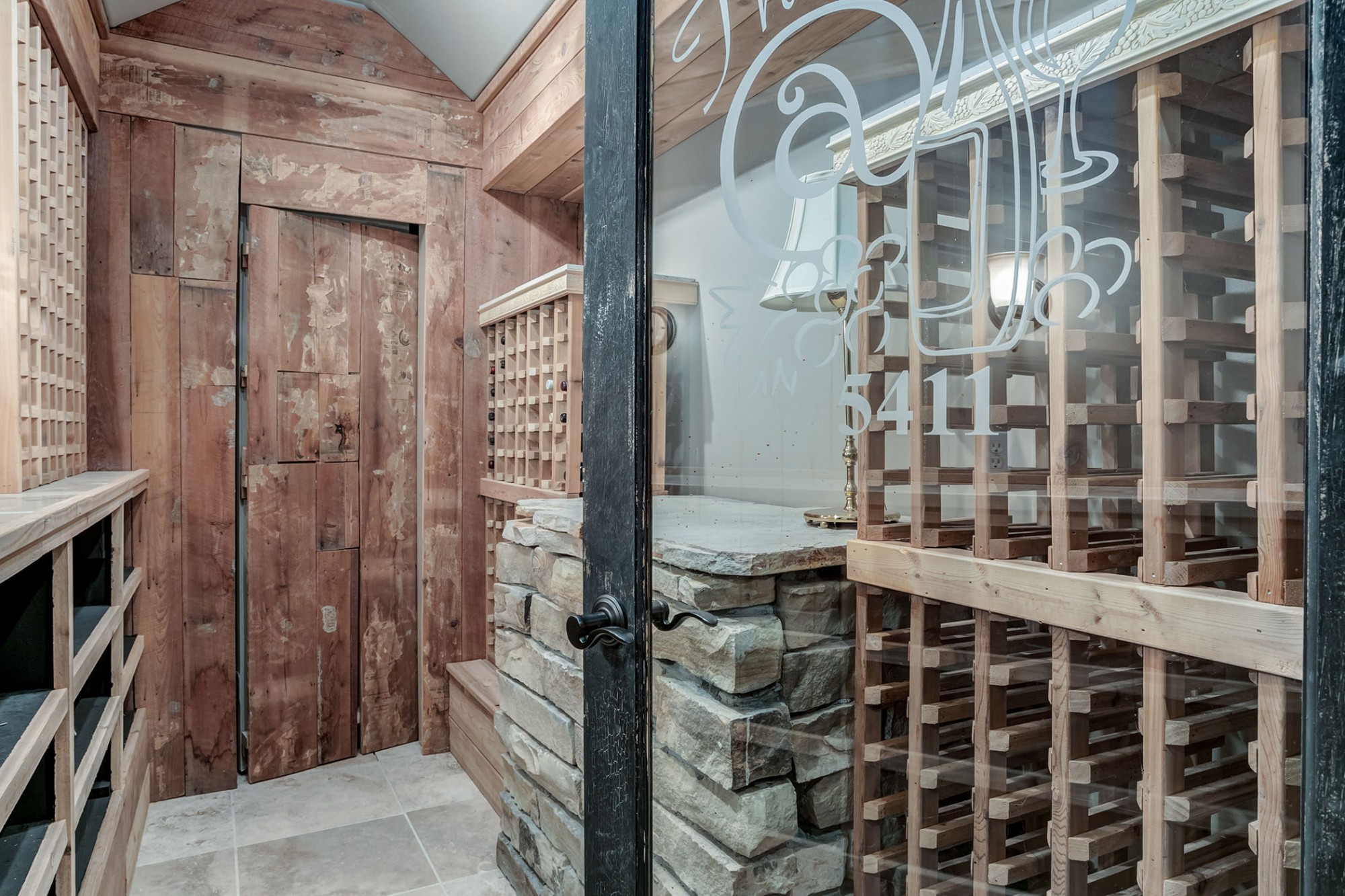 Enter through the custom etched door. The wine cellar can hold approximately 450 bottles, and there is also a hidden door leading to the tornado room!