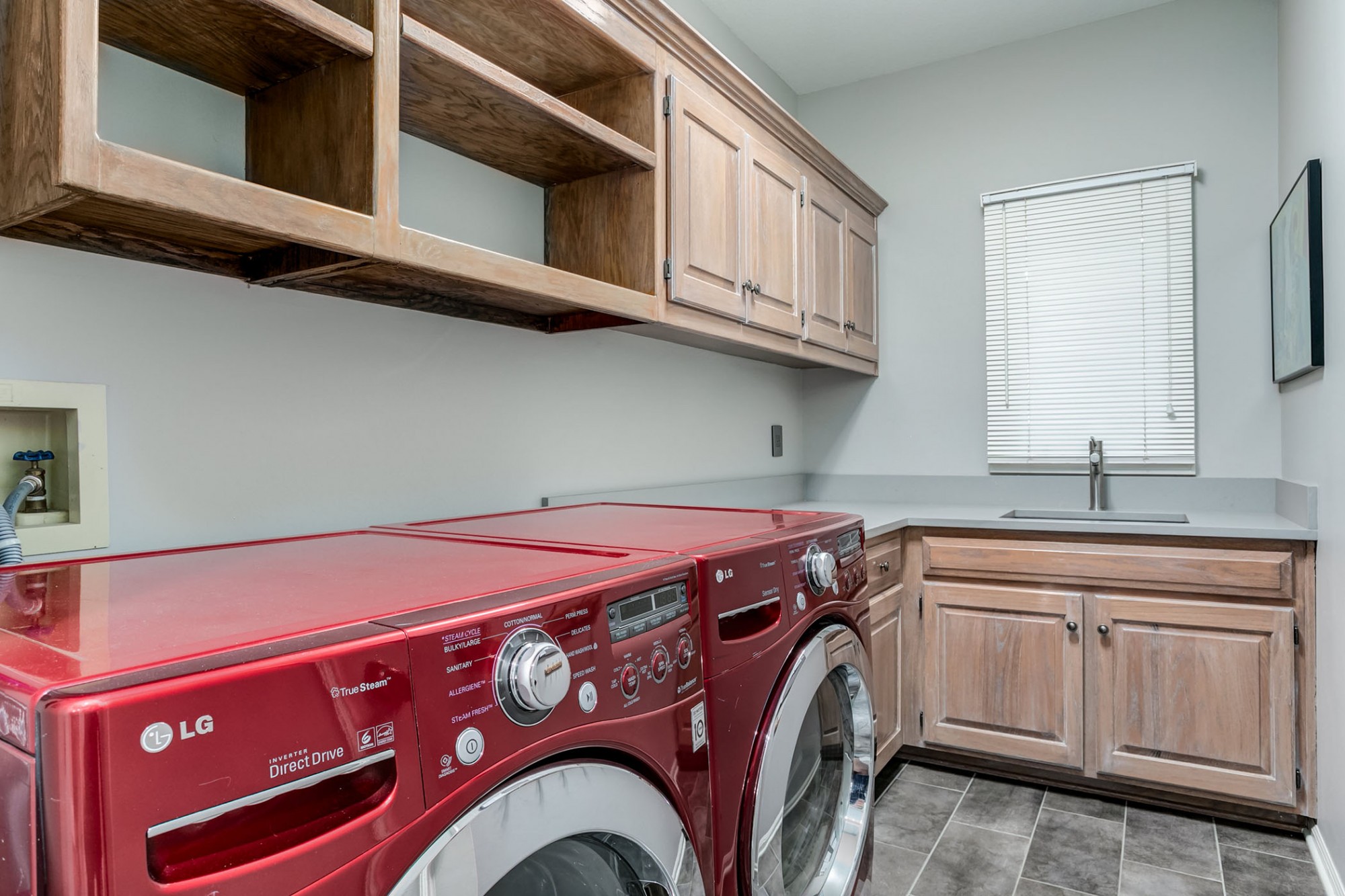 Laundry with nice storage and counter folding space  off kitchen and garage entry.