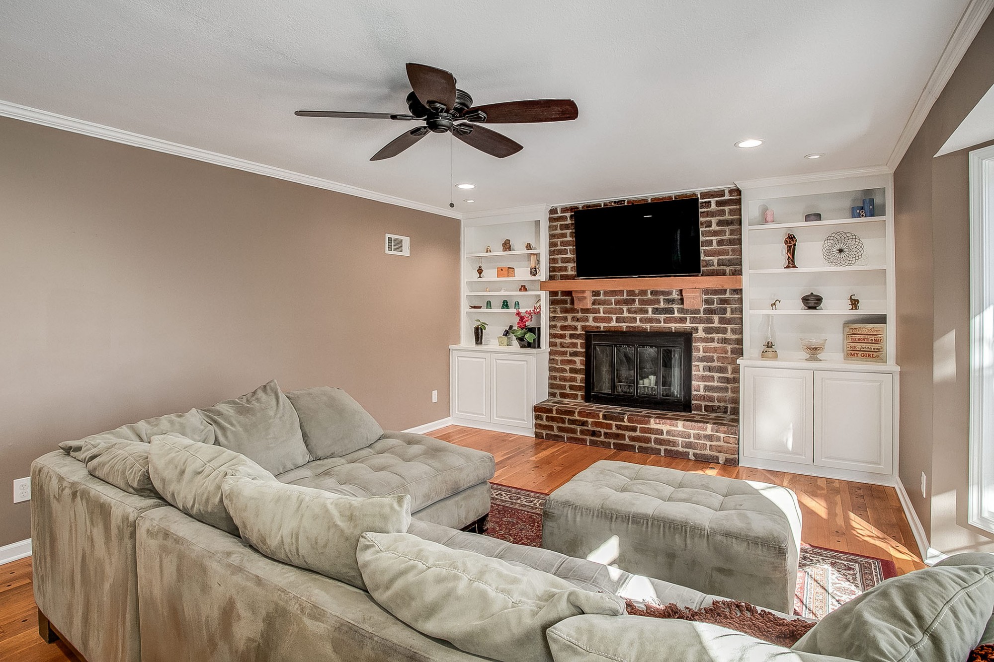 Continue to the first family room and relax by the handsome masonry floor-to-ceiling fireplace flanked by built-ins.