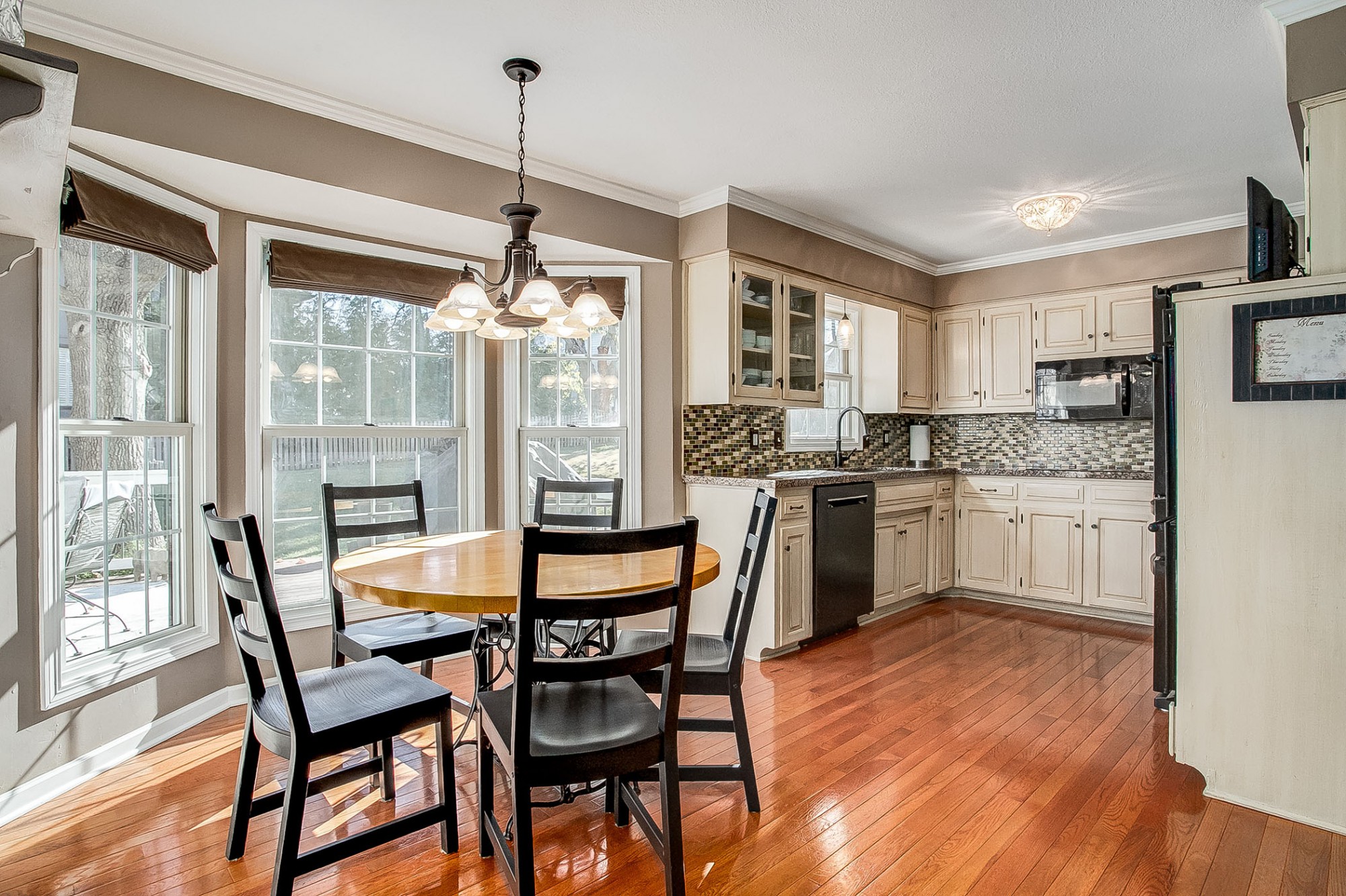 The family room opens to the updated, fully equipped, eat-in kitchen with breakfast area and another charming bay window.