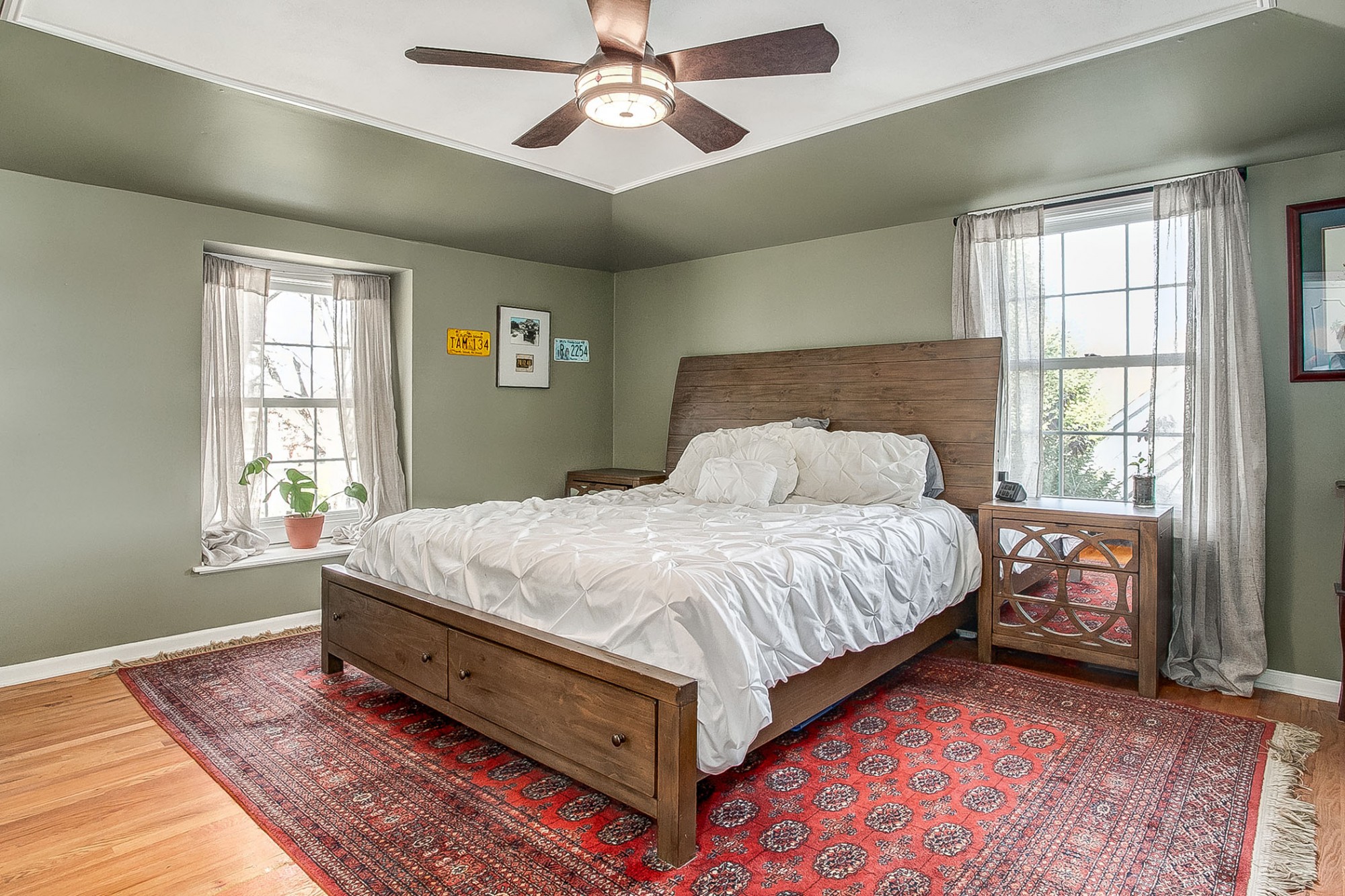 Ascend the stairs to the bedroom level. The spacious master suite highlights hardwood floors, stylish lighted ceiling fan, and charming windows.