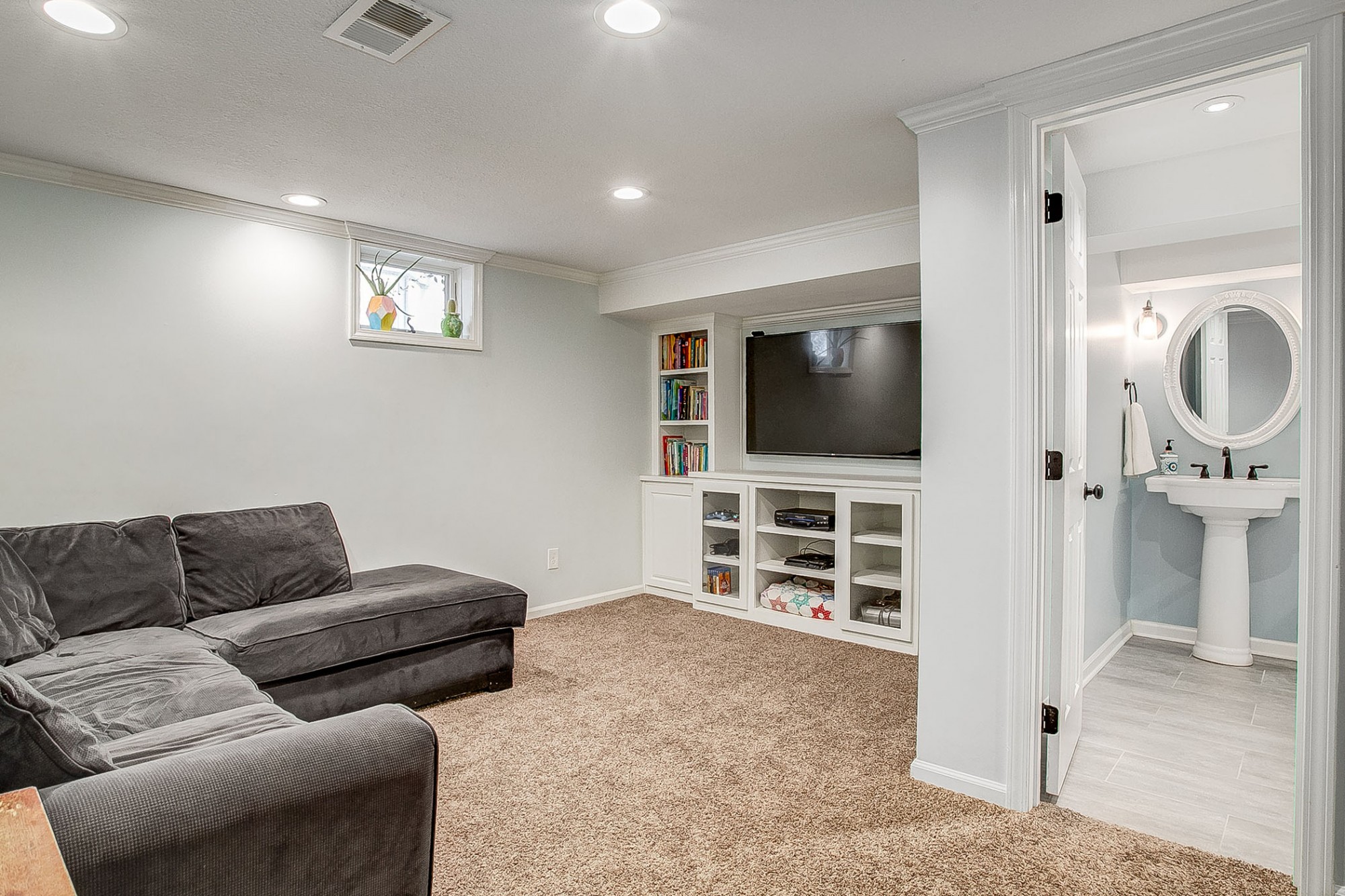 To the right of the stairs is a second family/media room with additional built-ins, along with the third full bath.